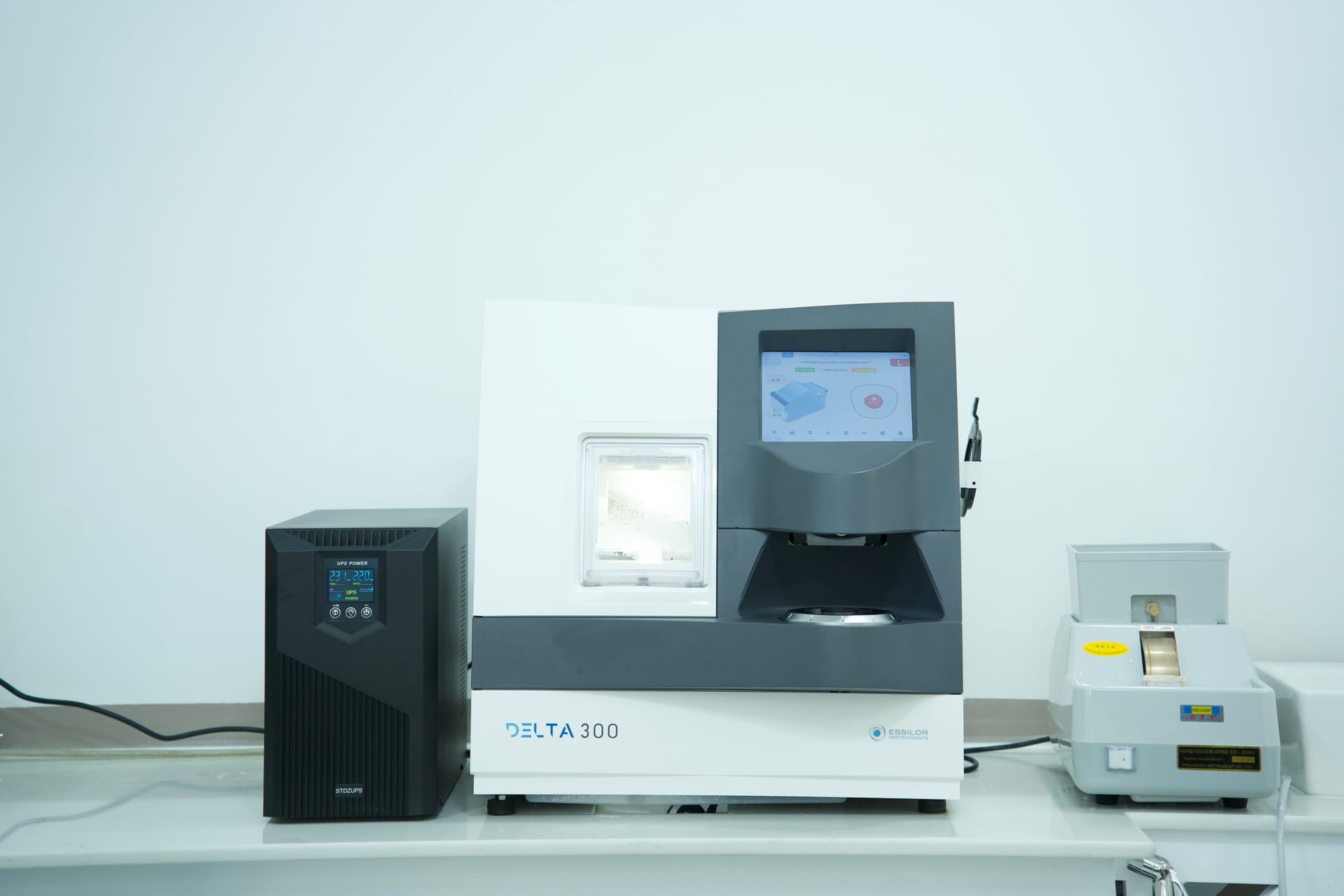 Computerized automatic lens edging and cutting machine shaping prescription lenses in M-Optic in-house optical laboratory